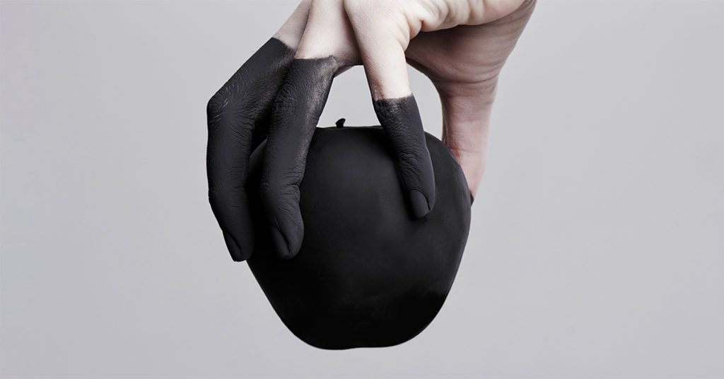 Hand holding black apple