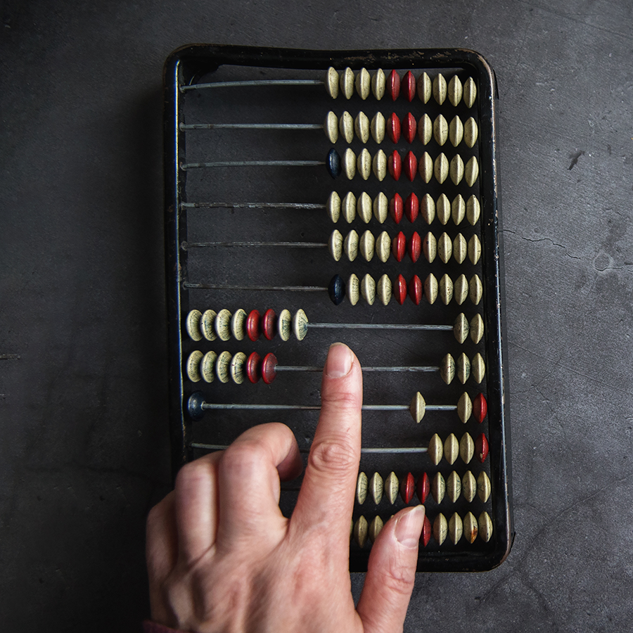 Hand manipulating beads of an abacus
