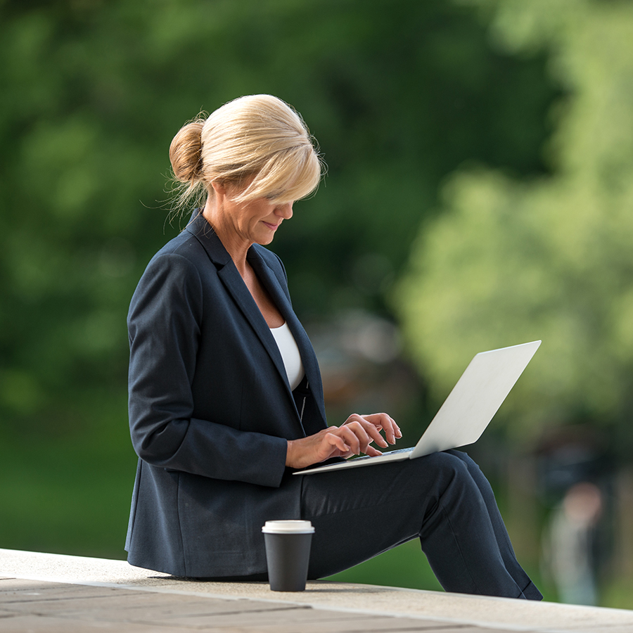 Business woman having coffee with laptop open