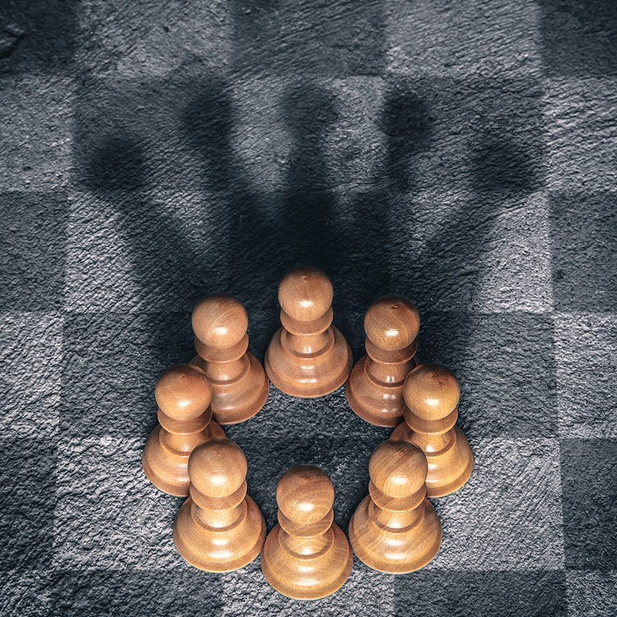 Circle of pawns casting the shadow of a king